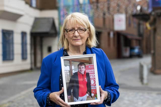 Dawn Jones outside the Corn Exchange, Cathedral Quarter in Belfast, holding an image of her son Timothy, who was a patient at Muckamore Abbey Hospital, as the first day of public hearings in the Muckamore Abbey Hospital Inquiry is under way