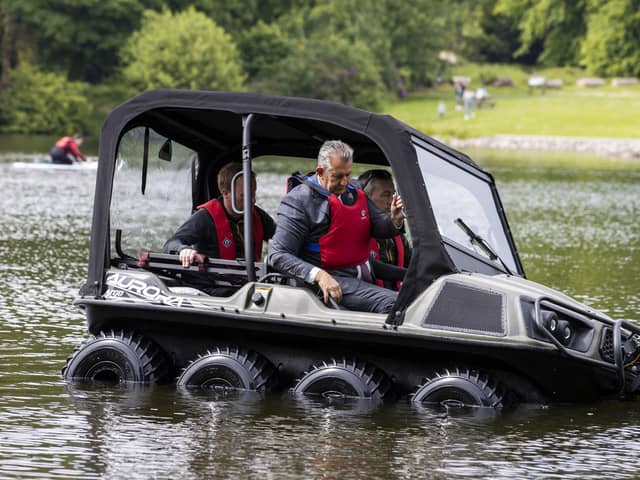 Environment Minister Edwin MLA sitting in the front passenger seat while being given a test drive in a new DAERA amphibious rescue vehicle during a visit Castlewellan Forest Park
