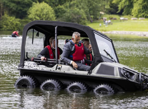 Environment Minister Edwin MLA sitting in the front passenger seat while being given a test drive in a new DAERA amphibious rescue vehicle during a visit Castlewellan Forest Park