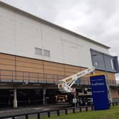The old Debenhams sign at Rushmere Shopping Centre in Craigavon, Co Armagh is removed by workmen today.