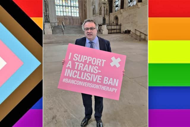 Stephen Farry in Westminster Hall, against the backdrop of an LGBTQQIABLM+ flag