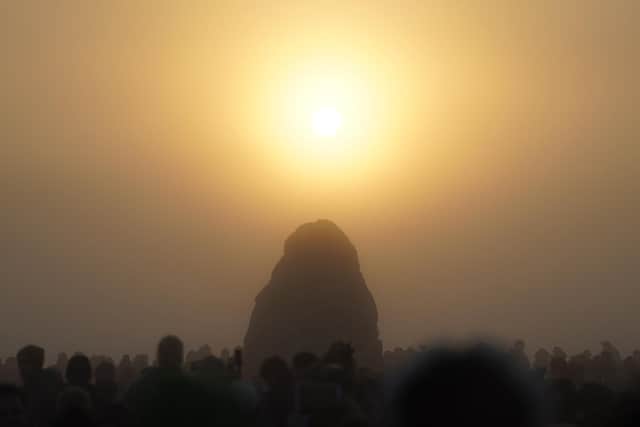 The sun begins to rise above the Heel Stone during the Summer Solstice at Stonehenge in Wiltshire. Picture date: Tuesday June 21, 2022.