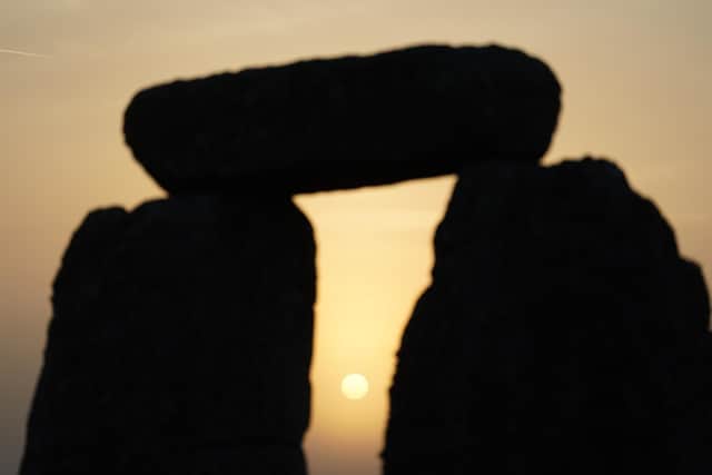 The sun begins to rise behind stones during the Summer Solstice at Stonehenge in Wiltshire. Picture date: Tuesday June 21, 2022.