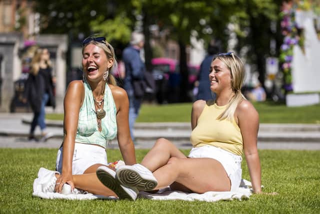 Anna Harper (left) and Leah Burdett enjoy the hot weather outside Belfast City Hall during the most recent spell of sunshine. Pic: Liam McBurney/PA Wire