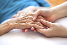 A generic photo of a woman holding a dementia sufferer's hands.
