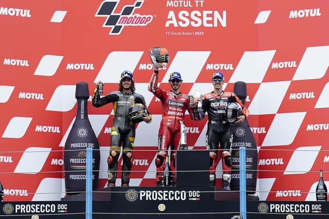 Motul TT Assen podium with race winner Pecco Bagnaia celebrating with Marco Bezzecchi and Maverick Viñales.