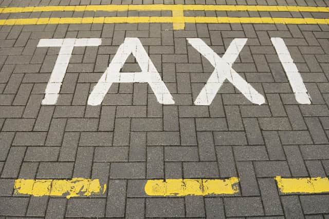 "Taxi markings painted on the road, with double yellow lines."
