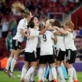 Julie Nelson is mobbed by her team-mates as they celebrate her scoring against Norway