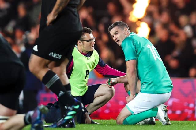 Johnny Sexton receives medical attention during the first test match against the All Blacks
