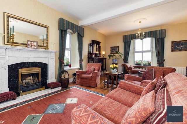 The drawing room features a marble fireplace with an open fire.