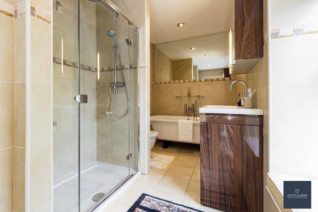 The bathroom has a modern four-piece suite including a walk in shower enclosure and a free-standing roll top bath.