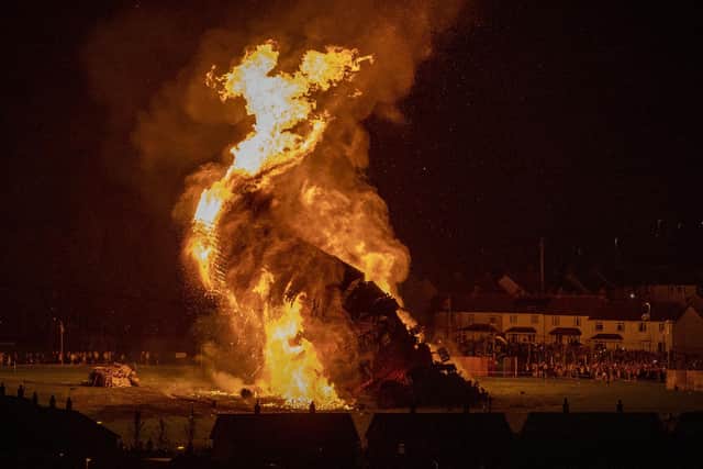 The Craigyhill loyalist bonfire in Larne topples over on the "Eleventh night" Picture: Liam McBurneyPA Wire