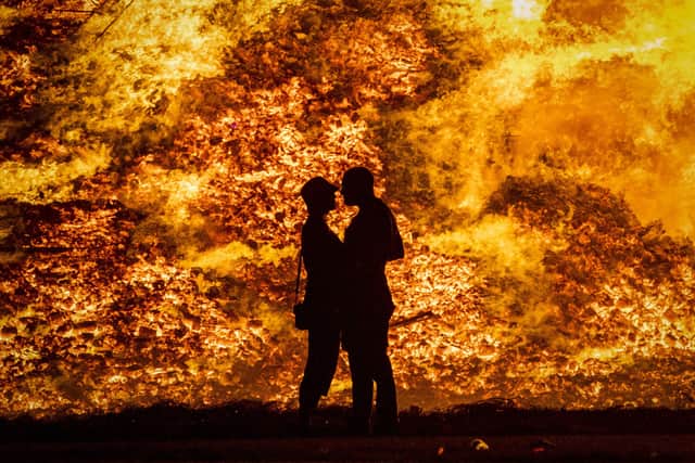 A couple embrace in silhouette at Craigyhill loyalist bonfire in Larne on the "Eleventh night". Picture: Liam McBurneyPA Wire