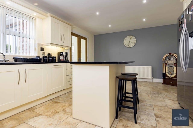 The kitchen / dining area has a full range of contemporary high and low level cream units with black granite worktop.