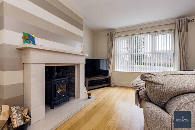 The living room has a feature fireplace with multi fuel stove and oak flooring.