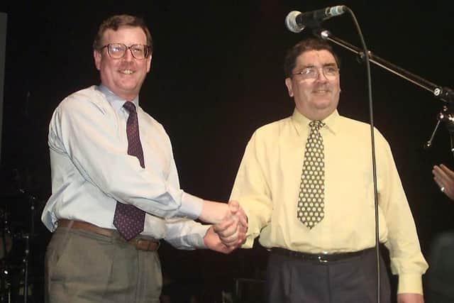 Ulster Unionist leader David Trimble and SDLP leader John Hume shake hands on stage, May 19, during a concert given by U2 and Ash at the Waterfront concert hall to promote the yes vote for Friday's peace referendum.  GERRY PENNY/AFP via Getty Images