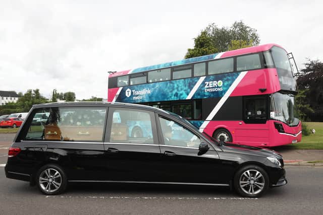The funeral cortege of the founder of WireWrightbus, Sir William Wright passes a zero emission bus outside Wrightbus factory in Ballymena ahead of his funeral service. Picture date: Wednesday July 27, 2022.