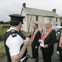 Worshipful master Bro John Finlay reads a statement to a police officer as the lodge are prevented from parading in Dunloy. Brethern walked the length of the Hall grounds as they were not permitted to walk to their church to hold their annual church service.Picture Steven McAuley/Kevin McAuley Photography Multimedia.