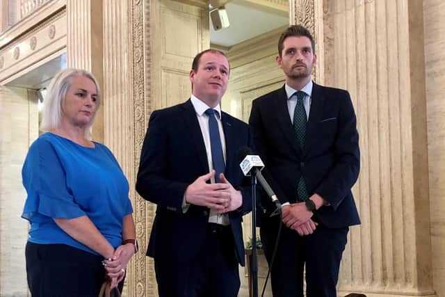 DUP minister Gordon Lyons (centre) speaks to the media alongside DUP MLAS Phillip Brett and Pam Cameron in the Great Hall, Parliament Buildings, Stormont.