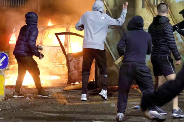 Nationalist youths throw stones at Loyalist throughthe security gate at Lanark Way interface in Belfast during a riot on Wednesday night. Loyalists had blocked traffic during a protest which then erupted into a riot.
PICTURE BY STEPHEN DAVISON