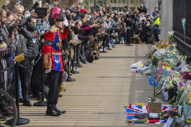 A man arrives to lay a floral tribute outside Buckingham Palace, London, following the announcement of the death of the Duke of Edinburgh at the age of 99.