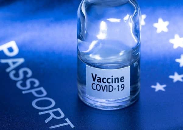 A picture taken on March 3, 2021 in Paris shows a vaccine vial reading "Covid-19 vaccine" on an European passport.
(Photo by JOEL SAGET / AFP) (Photo by JOEL SAGET/AFP via Getty Images)