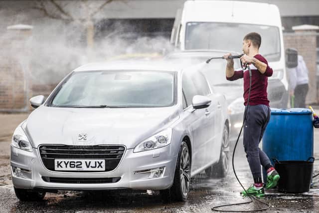 Cars being washed at a car wash on Bloomfield Road in east Belfast as Northern Ireland eases its restrictions. PA Photo. Picture date: Monday April 12 2021. See PA story ULSTER Coronavirus. Photo credit should read: Liam McBurney/PA Wire