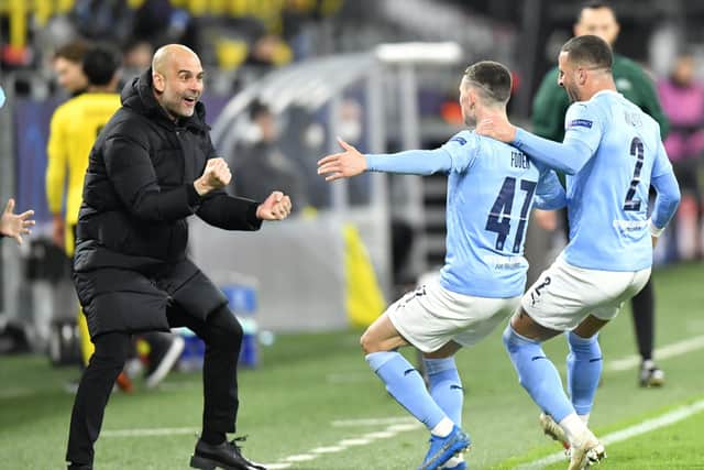 Manchester City manager Pep Guardiola celebrates with goal scorer Phil Foden and Kyle Walker (right) after their second goal during the UEFA Champions League, quarter final, second leg match at Signal Iduna Park in Dortmund, Germany.
