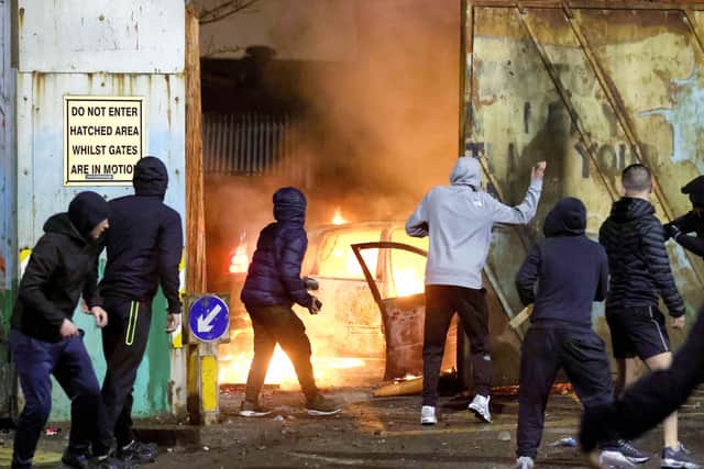 Nationalist youths throw stones at loyalists through the security gate at Lanark Way interface in Belfast during a riot on Wednesday April 7. Picture by Stephen Davison