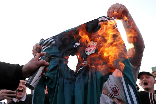 Fans burn a Liverpool replica shirt outside Elland Road against Liverpool's decision to be included amongst the clubs attempting to form a new European Super League.