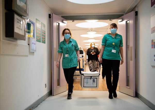Pharmacists transport a cooler containing the Moderna vaccine, at the West Wales General Hospital in Carmarthen, the third vaccine to be approved for use in the UK, to be given to patients in Wales. Picture date: Wednesday April 7, 2021.