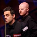 Anthony McGill looks on behind Ronnie O'Sullivan during their match in the Betfred World Snooker Championships