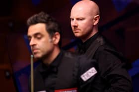 Anthony McGill looks on behind Ronnie O'Sullivan during their match in the Betfred World Snooker Championships