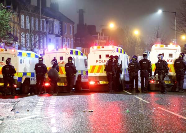 A line of police at disturbances in west Belfast last month; the poll asked if re-unification would strain peace further