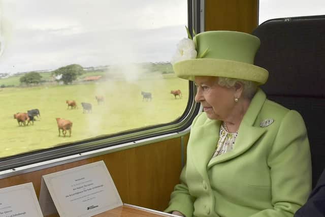 Queen Elizabeth II  travelling by steam train along the North Antrim coast from Coleraine to Bellarena