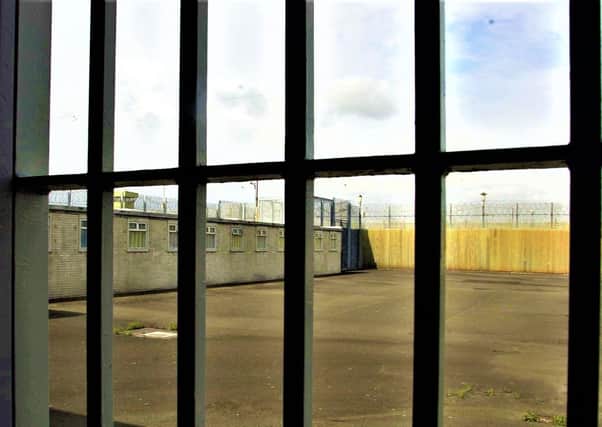 Looking through a cell’s bars at an exercise yard at The Maze prison