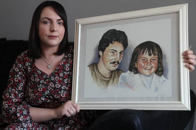 Charlene Smyth, holds a painting of herself with her father Charlie McGrillen, who was killed by the UFF in 1988. PA image