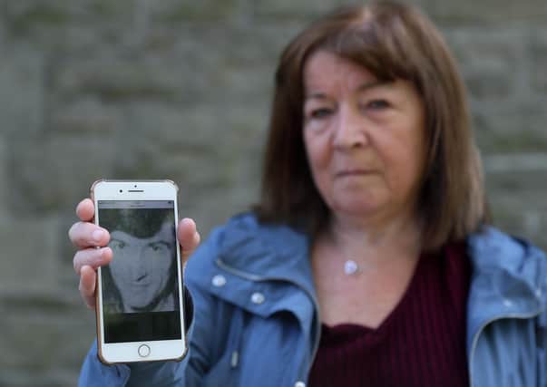 Margaret Valente, displays an image of her husband Peter who was killed by the IRA in Belfast in 1980, at the WAVE Trauma Centre in Belfast. PA image