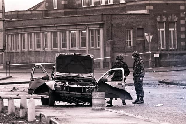 Belfast, 1991: Two soldiers survey a taxi, blown up with the driver and his lady passenger inside
