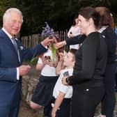 Charles is presented with a bunch of bluebells by a south Armagh family during his visit to Slieve Gullion Forest Park.