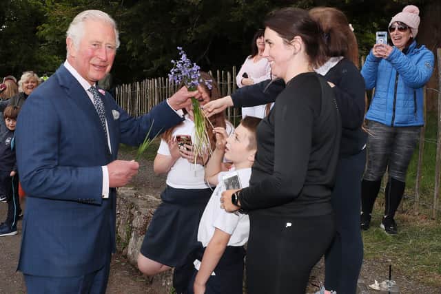 Charles is presented with a bunch of bluebells by a south Armagh family during his visit to Slieve Gullion Forest Park.