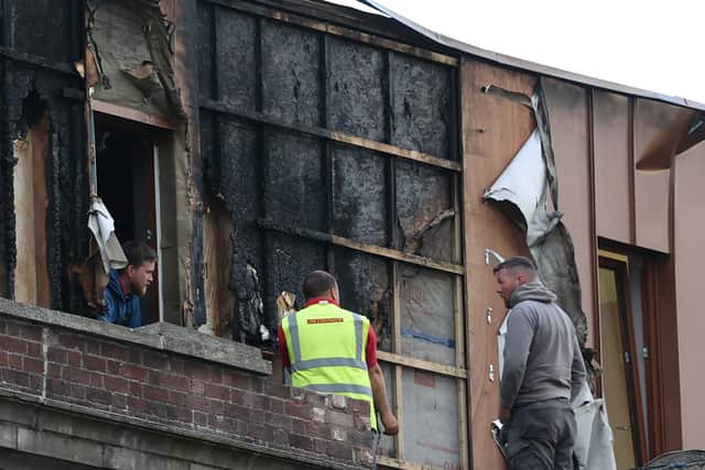 Workers clear debris around the Malone Exchange on the Lisburn Road, Belfast, where there was a fire in the building's penthouse earlier on Tuesday. Over 40 firefighters attended the scene. Picture date: Tuesday May 18, 2021.