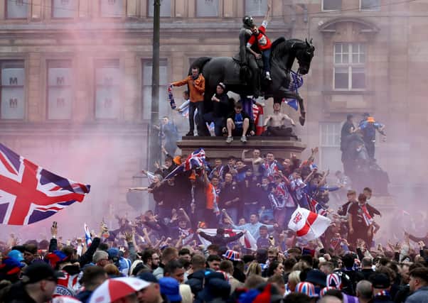 Rangers fans celebrate winning the Scottish Premiership in George Square. Photo: Andrew Milligan/PA Wire.