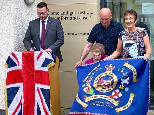 Mrs Emily Clarke being presented with the first of the LCC's NI Centenary flags at the Somme Nursing Home in east Belfast.