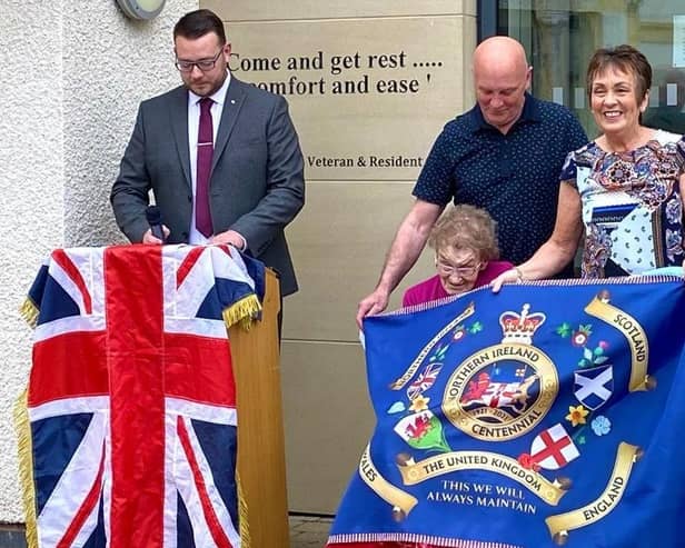 Mrs Emily Clarke being presented with the first of the LCC's NI Centenary flags at the Somme Nursing Home in east Belfast.