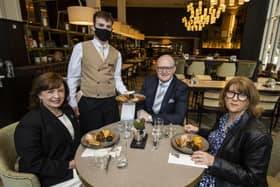 Northern Ireland Economy Minister Diane Dodds (left) welcomes the reopening of indoor hospitality at the Grand Central Hotel in Belfast with Janice Gault (right) of the Northern Ireland Hotels Federation (NIHF) and General Manager Stephen Meldrum (second from right) as they are being served  the hotel's house breakfast by Conor Sullivan.