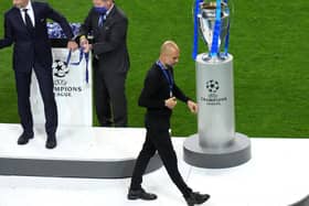 Manchester City manager Pep Guardiola with the runners up medal as he walks past the Champions League trophy at Estadio do Dragao in Porto.
