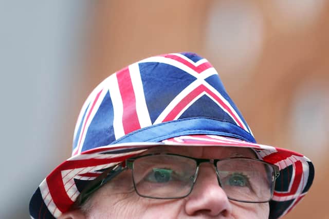 Jim Taggart sports a Union Jack hat and tie as he watches the bands parade on the Shankill Road, Belfast