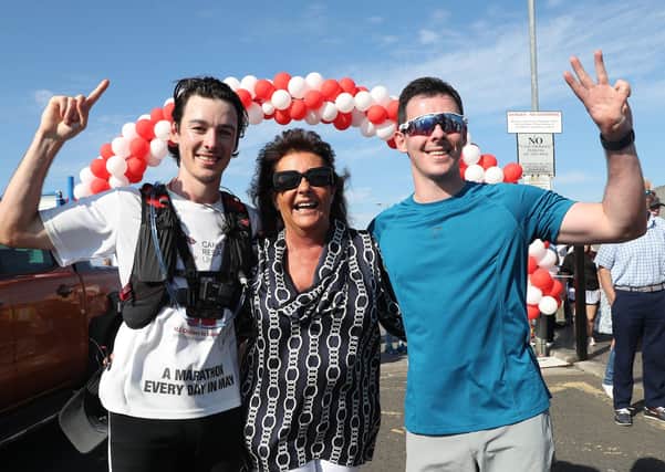 Joshua Eastwood finishes his 31st marathon in May. He's joined by his mum Gail and twin brother Jacob. 
Photograph by Declan Roughan