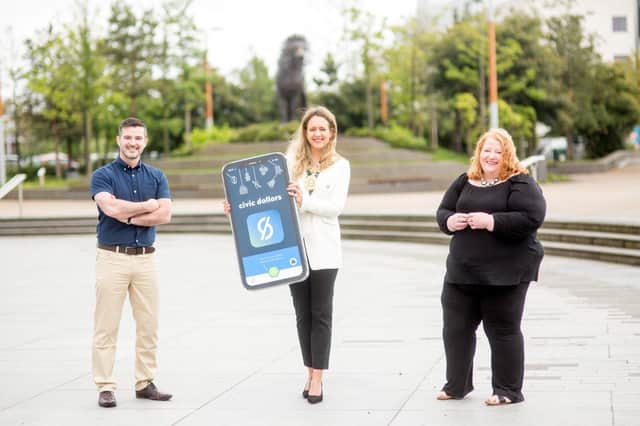 Stephen McPeake, CEO of local company Moai Digital Ltd and creator of the Civic Dollars app, Belfast Lord Mayor Councillor Kate Nicholl and Justice Minister, Naomi Long launch the new ‘Civic Dollars’ mobile phone app